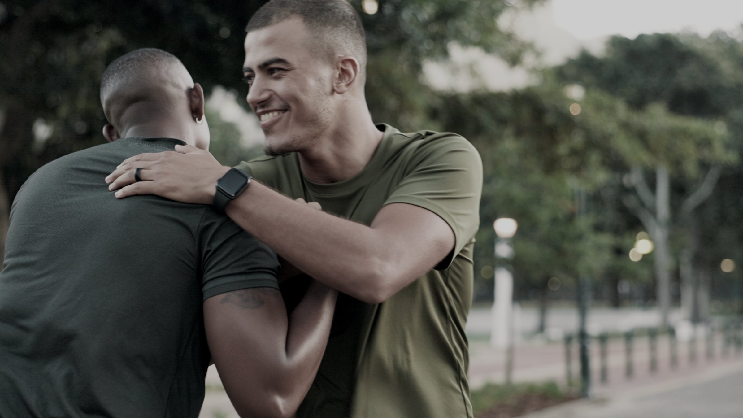 Two dads embracing in a park