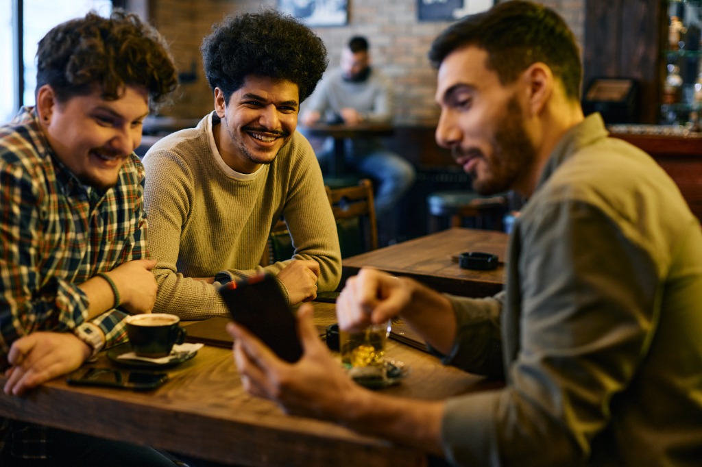 Three dads laughing around a table